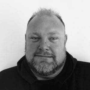 A black and white photo of a man with beard.