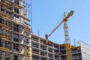 A crane is in front of some buildings.