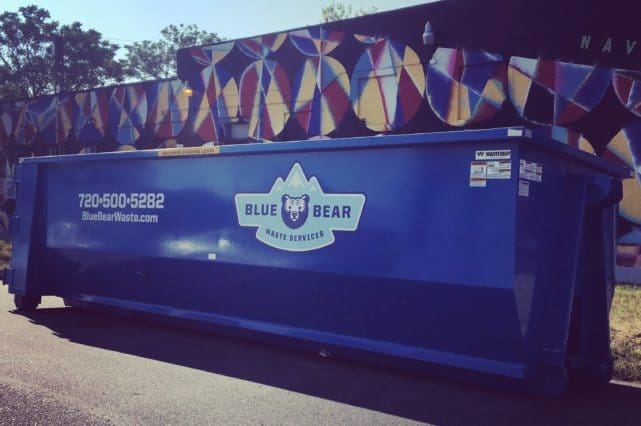 A dumpster sitting on the side of a road.