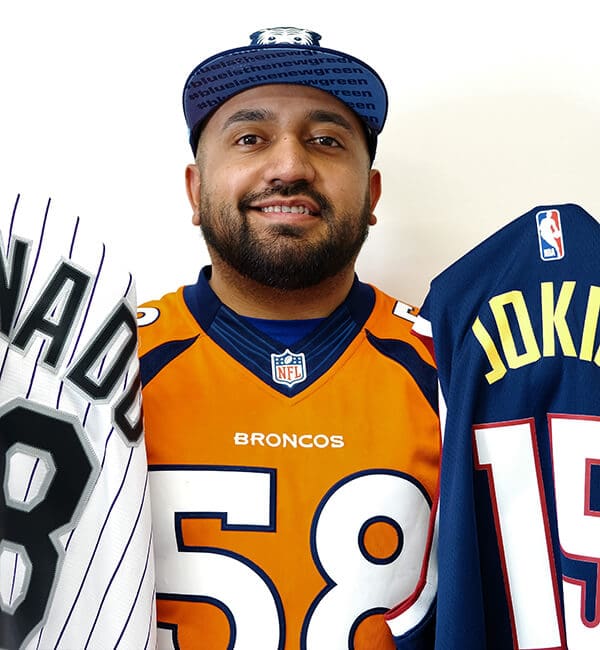 A man holding two jerseys in front of him.