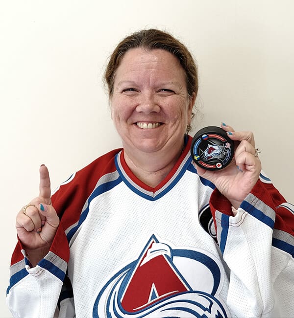 A woman in hockey uniform holding up her finger.