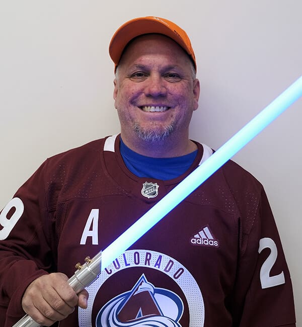 A man holding a light saber in his hand.