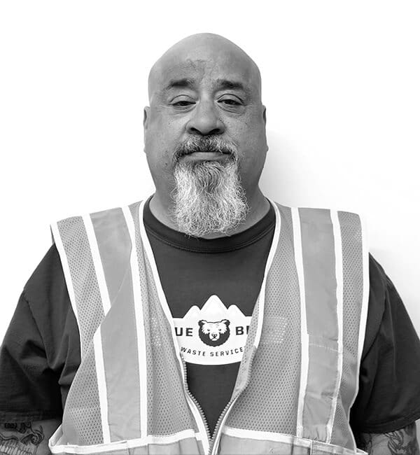 A man with a beard and mustache wearing safety vest.