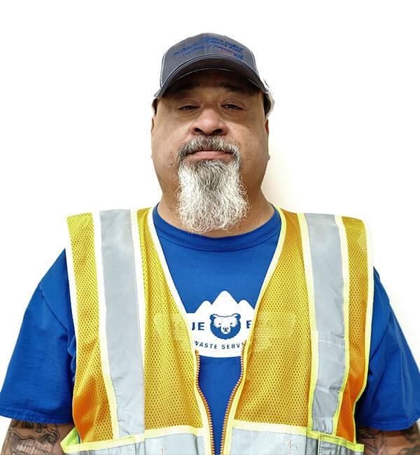 A man in an orange vest and blue shirt.