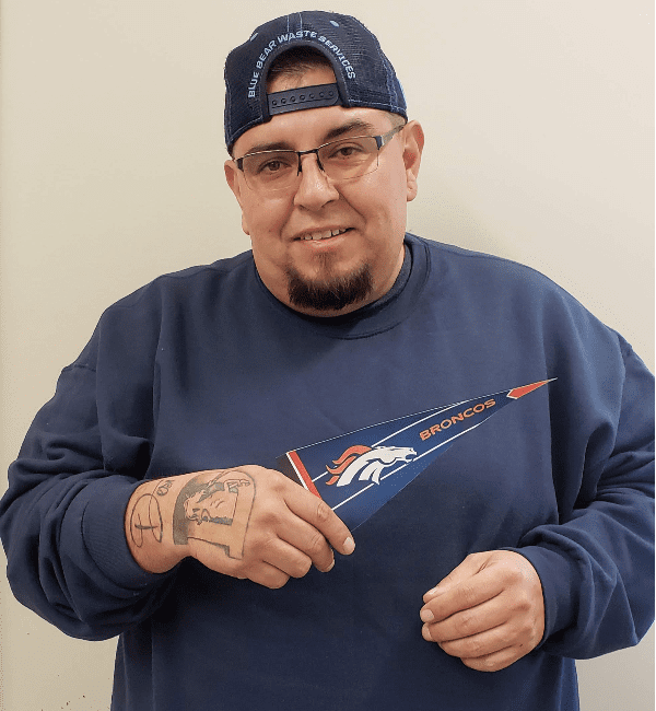 A man holding an umbrella with the nfl logo on it.