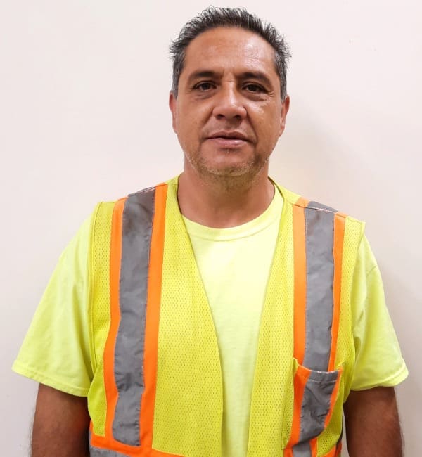 A man in an orange vest and yellow shirt.