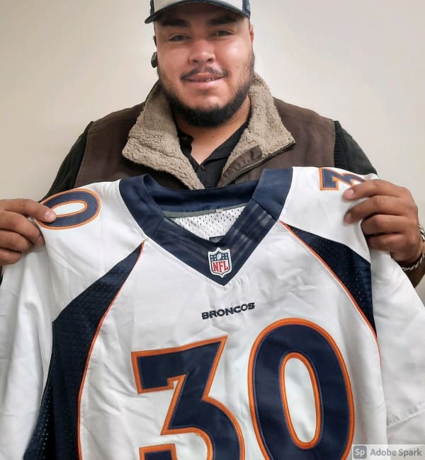 A man holding up a football jersey.