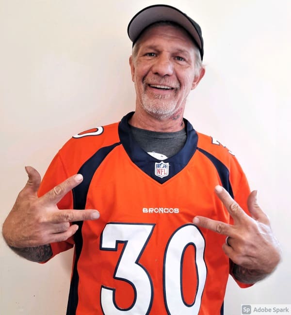 A man in an orange football jersey and hat.