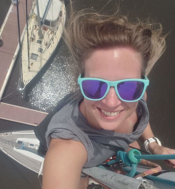 A woman with sunglasses on top of a boat.