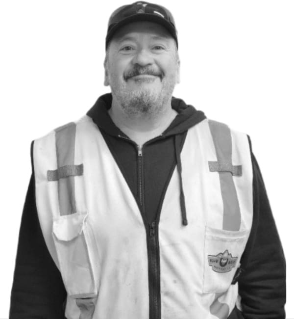 A man in a black and white photo wearing safety vest.