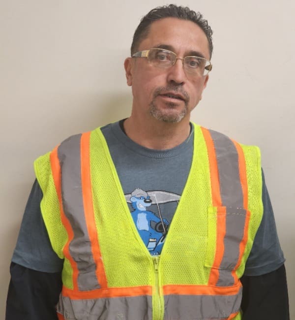 A man wearing safety vest and glasses