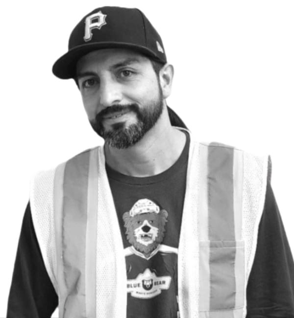 A man wearing a baseball cap and vest.