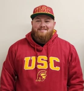 A man with a beard wearing a usc sweatshirt.