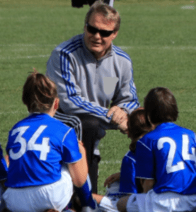 A coach talking to the girls on the field