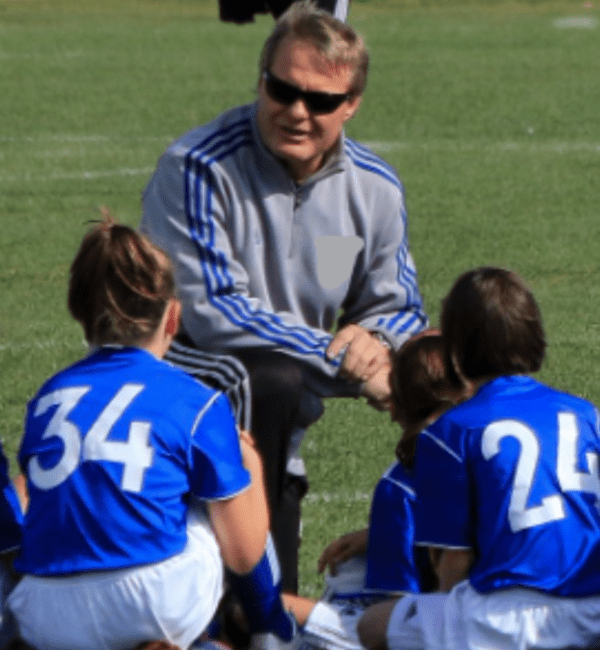 A coach talking to the girls on the field