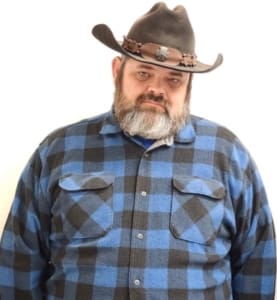 A man in a cowboy hat and plaid shirt.