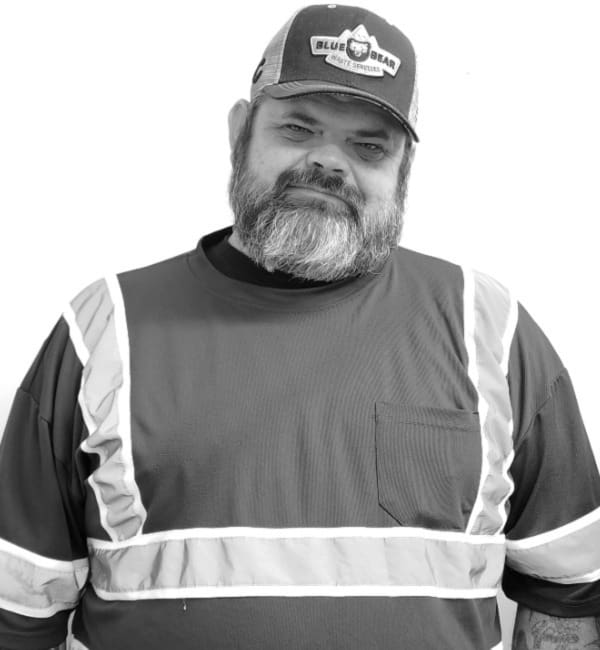 A man in a hat and safety vest.