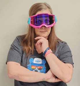 A woman wearing goggles and looking at the camera.