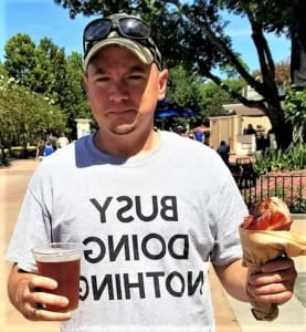 A man holding a hot dog and beer.